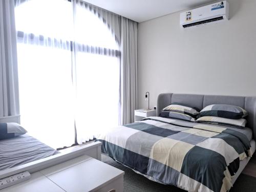 a bedroom with a bed and a large window at Tulip River View in Ma‘mūrah