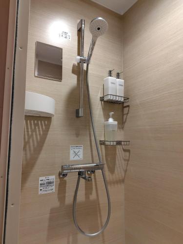 a shower in a bathroom with a shower head at Dragon Inn Nikko in Nikko