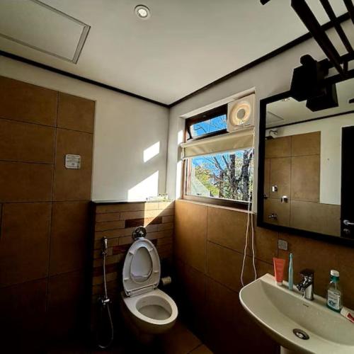a bathroom with a toilet and a sink at Red Panda Jungle Camp - A Unit of Davinchi Homes Pvt Ltd in Gyalzing