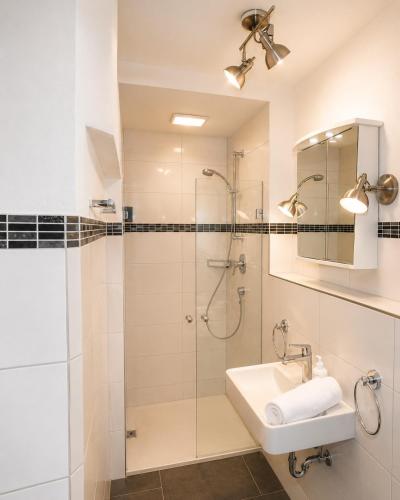 a bathroom with a shower and a sink at Apartmenthaus Ahorn in Mittelberg