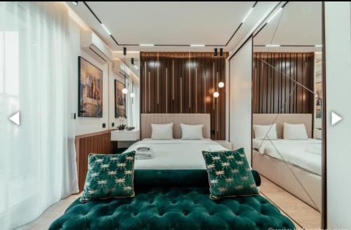 a bedroom with two beds and a green ottoman at BW LUX STUDIO-Belgrade Waterfront in Belgrade