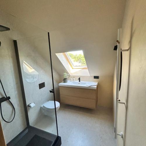 a bathroom with a sink and a toilet and a window at WILLOW in Pāvilosta
