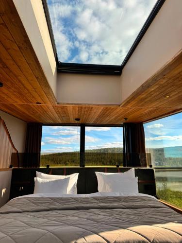 a bedroom with large windows and a large bed at Jänkä Resort in Äkäslompolo