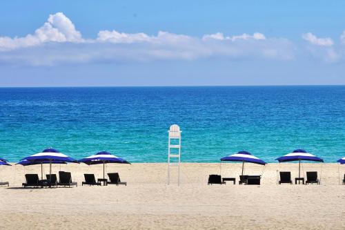 a group of chairs and umbrellas on a beach at Kensington Resort Seorak Beach in Sokcho