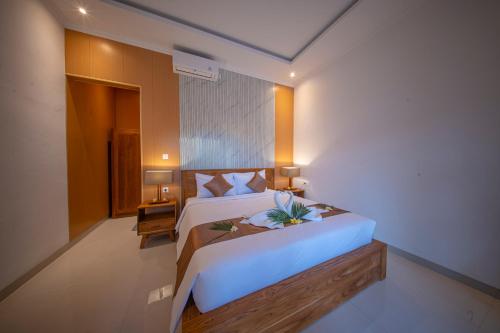 a bedroom with a large white bed in a room at Eva Guest House in Canggu