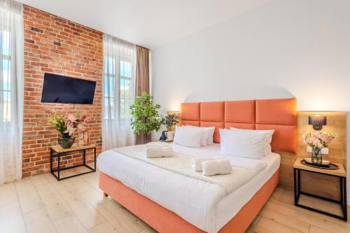 a bedroom with a large bed and a brick wall at Hotel Jazz Market Square Wroclaw in Wrocław