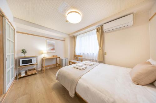 ein Schlafzimmer mit einem großen weißen Bett und einem Fenster in der Unterkunft Comfy Stay Sakuramachi in Nara