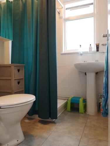 a bathroom with a toilet and a sink and a window at SHORTIEs STAYS in Hemsby