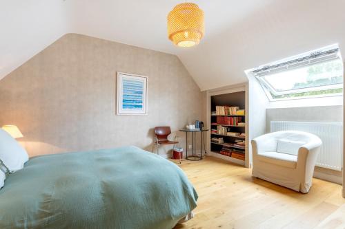 a bedroom with a bed and a chair and a window at Une Chambre À Lestriguiou in Plomeur