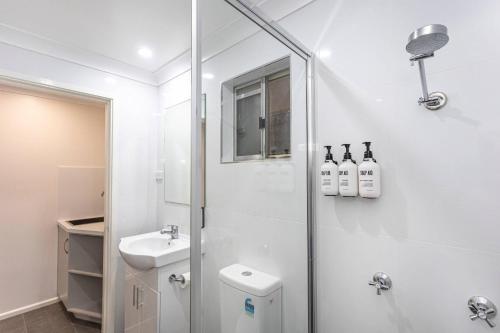a bathroom with a shower and a toilet and a sink at Econo Lodge Alabaster Motel Cowra in Cowra