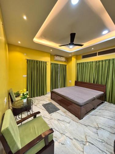 a bedroom with a bed and a table and green curtains at Unique Nest Homestay in Guwahati