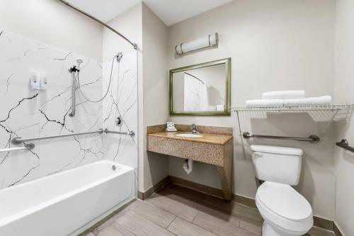a bathroom with a toilet and a sink and a tub at Quality Inn Laredo - Nuevo Laredo in Laredo