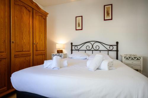a bedroom with a white bed with white pillows at Chez Romane in Riquewihr
