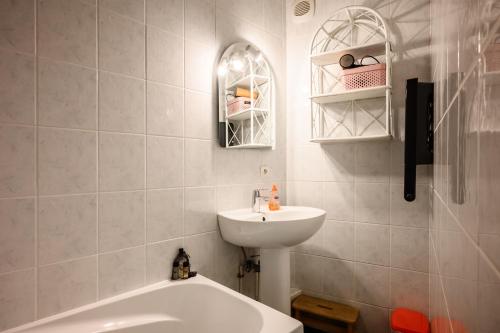 a white bathroom with a sink and a toilet at Chez Romane in Riquewihr