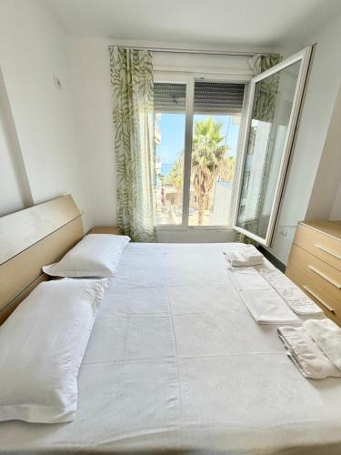 a large white bed in a room with a window at Seaview Apartment in Dhërmi
