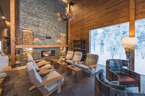 a lobby with chairs and a fireplace in a lodge at Wilderness Hotel Saariselkä in Saariselka