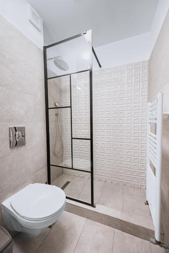 a bathroom with a toilet and a glass shower at Escape Vama Veche in Vama Veche