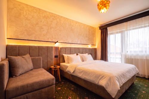 a bedroom with a bed and a couch at Vila Hora cu Brazi in Zărneşti