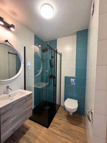a bathroom with a sink and a shower and a toilet at Diament Apartamenty in Rowy