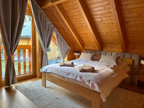 a bed in a room with a wooden ceiling at Chata Mila in Veľká Lomnica