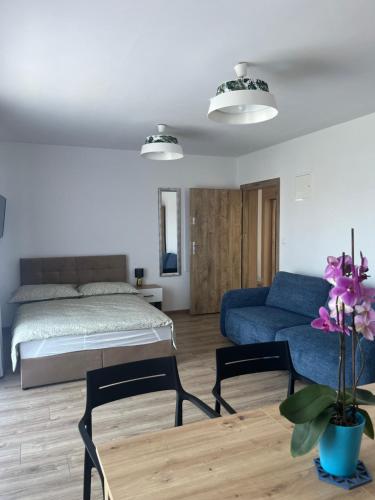 a living room with a bed and a couch at Diament Apartamenty in Rowy