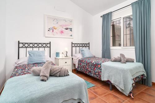 a bedroom with two beds and a window at El Rincón de Esther in Cómpeta