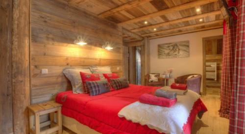 um quarto com uma grande cama vermelha num quarto em Chambres d'hôtes de charme Douglas em Samoëns