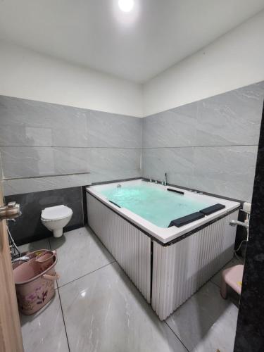 a bath tub in a bathroom with a toilet at Hotel Namaste Ac Rooms in Vadodara