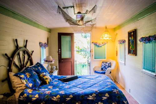 a bedroom with a bed with a blue comforter at Featherbed Railroad in Upper Lake