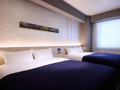 a room with two beds and a window at Minn Namba Nipponbashi in Osaka