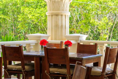 a table and chairs with flowers on a patio at Cielo Maya Beach Tulum in Tulum