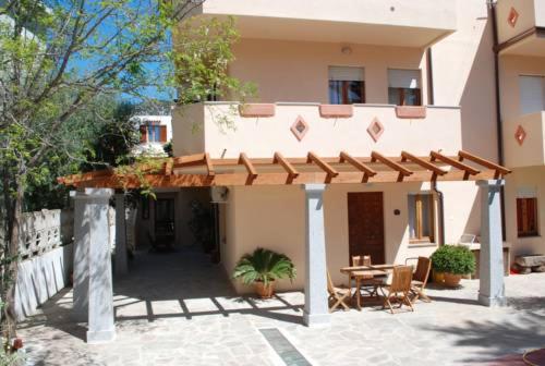 a house with a patio and a table in front of it at Apartment Stella Maris in Cala Gonone
