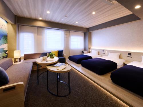 a room with two beds and a couch at Minn Namba Nipponbashi in Osaka