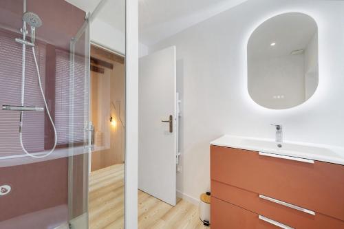 a bathroom with a sink and a mirror at Appartement rénové centre Crozon in Crozon