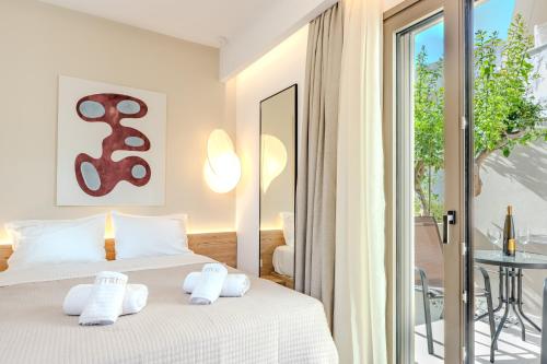 a bedroom with a bed with white towels on it at Citrus 5 Urban Studios in Mastambás