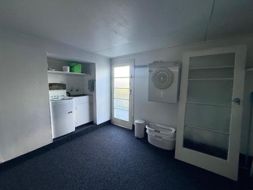 a kitchen with a washer and dryer and a window at B&B on Hoffman in Hokitika