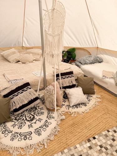 a room with a tent with blankets and pillows at Glempings MIGLA in Dalbe