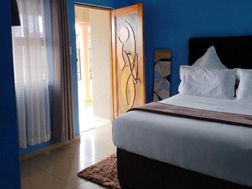 a bedroom with a large bed with a wooden door at Zamdu Lodge in Nkandla
