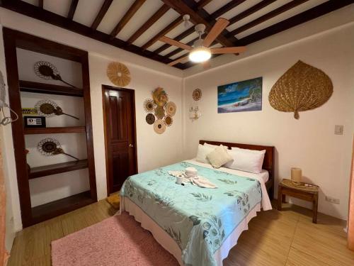 a bedroom with a bed with a green comforter at Latitude 10 Siargao in General Luna