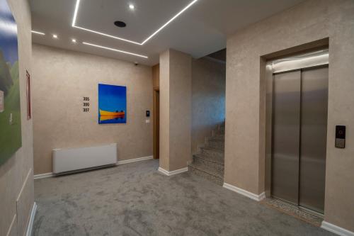 a hallway with a staircase and a painting on the wall at Grand Station Hotel in Shkodër