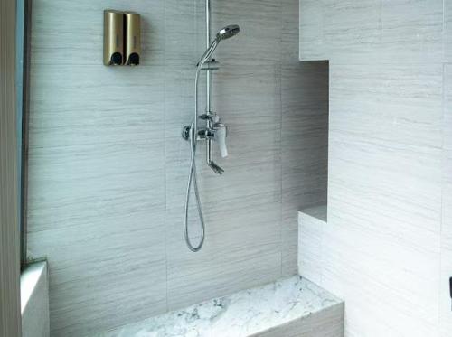 a shower with a shower head in a bathroom at lee hotel lat phrao in Bangkok