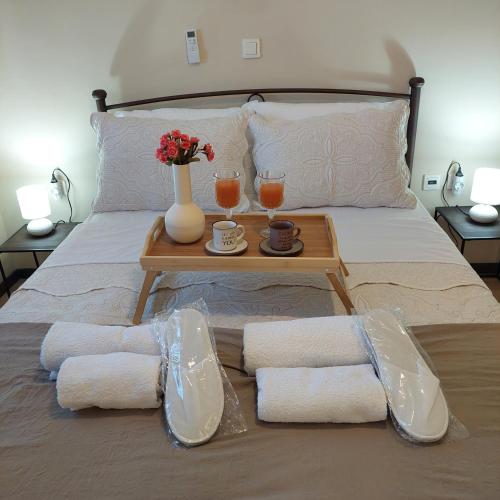 a bed with a table with towels and two glasses at The Mastiha Spot 8 in Chios