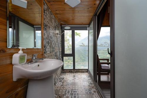 a bathroom with a sink and a large window at Catcat Garden House in Sapa