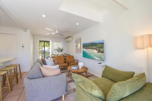 a living room with couches and a table at Riverside Retreat, Noosaville in Noosaville