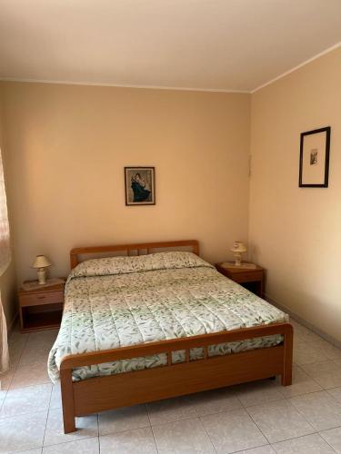 a bedroom with a bed and two nightstanduments sidx sidx sidx sidx at Casa Le Araucarie in Mascali