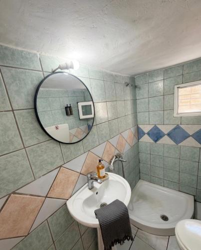 a bathroom with a sink and a mirror and a toilet at FLISVOs 70 m από την θάλασσα in Erateini