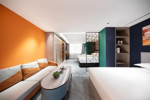 a bedroom with a couch and a bed in a room at 义乌君威酒店 in Yiwu