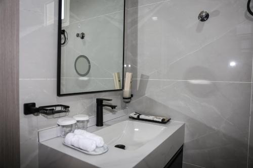a white bathroom with a sink and a mirror at paradise resort and spa in Hatta