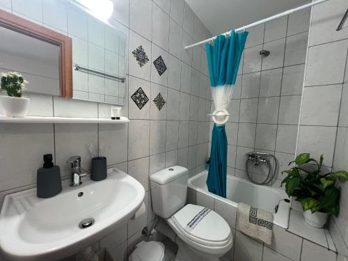 a bathroom with a sink and a toilet and a tub at Heaven Studios & Apartments in Stalís