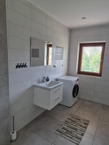 a bathroom with a washing machine and a sink at Spełnienie Marzeń Bóbrka in Bóbrka